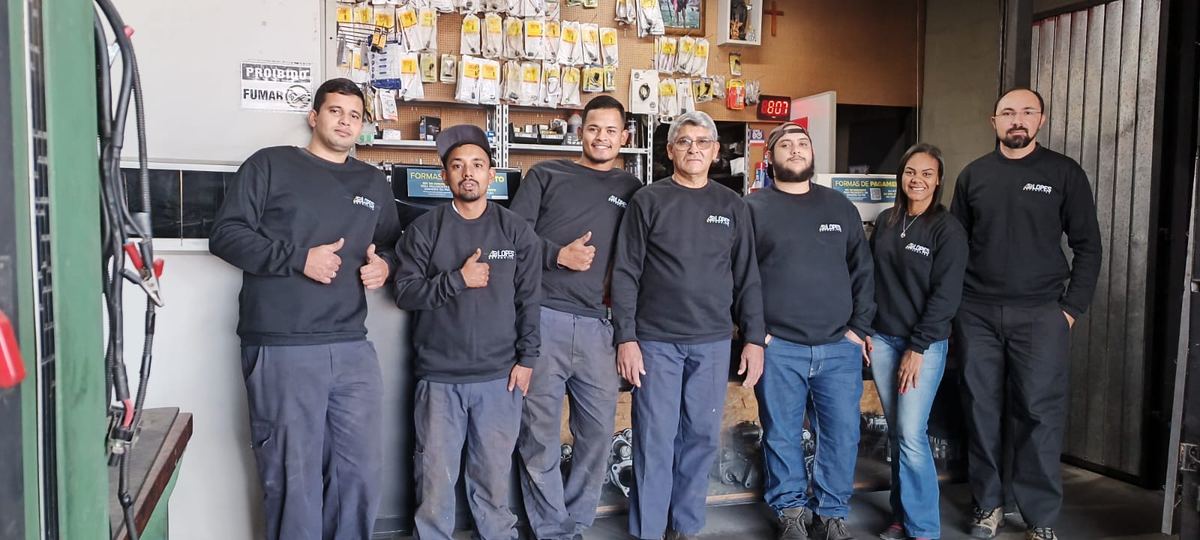 Equipe da Lopes Automotiva, de uniforme, no balcão da loja
