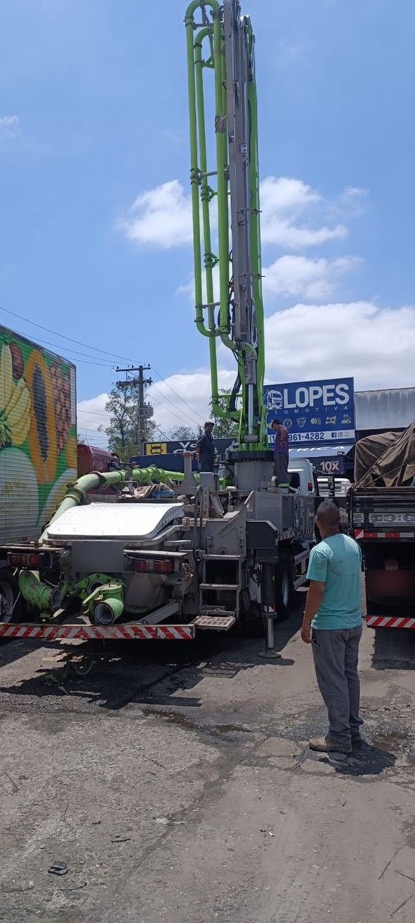 Caminhão-bomba de concreto no pátio, com o letreiro da Lopes ao fundo